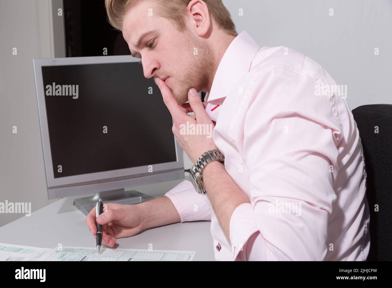 young man works hard at his tax declaration on his desk Stock Photo