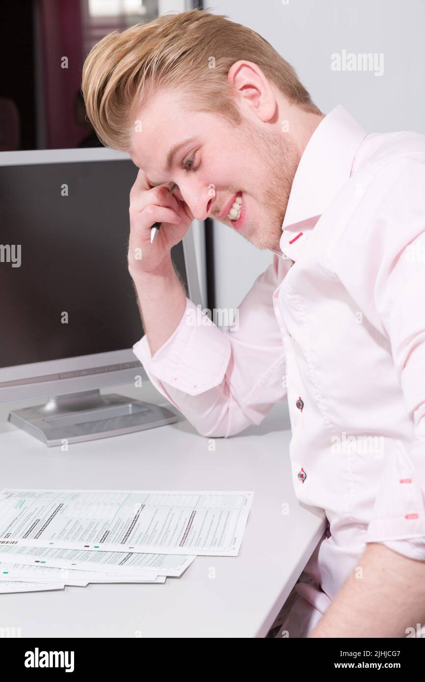 young man works hard at his tax declaration on his desk Stock Photo