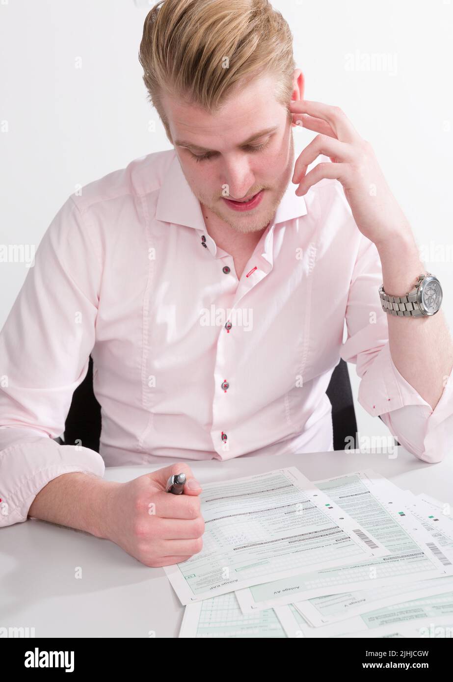 young man works hard at his tax declaration on his desk Stock Photo
