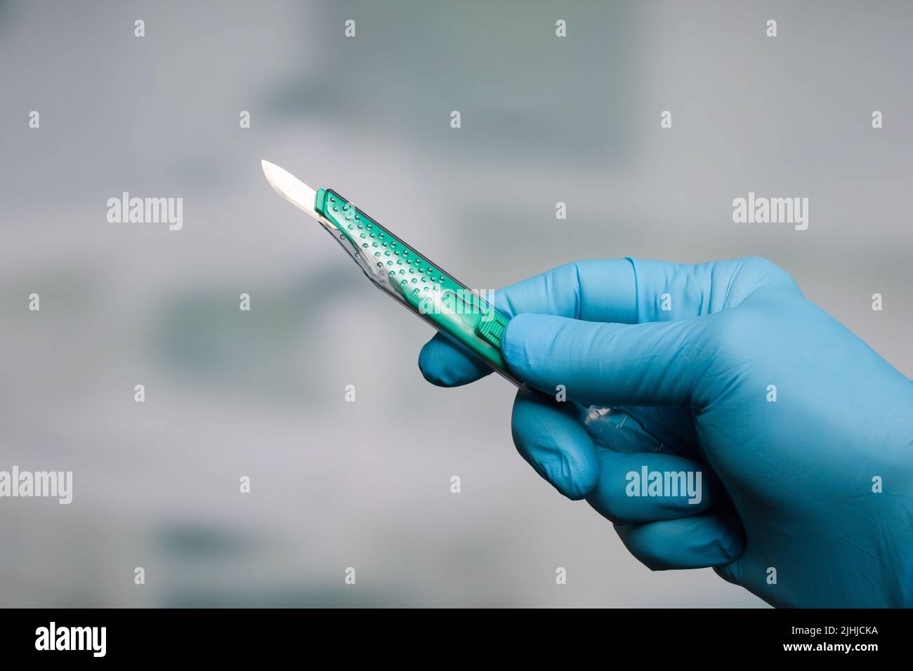 Doctor's hand with a new disposable scalpel Stock Photo Alamy