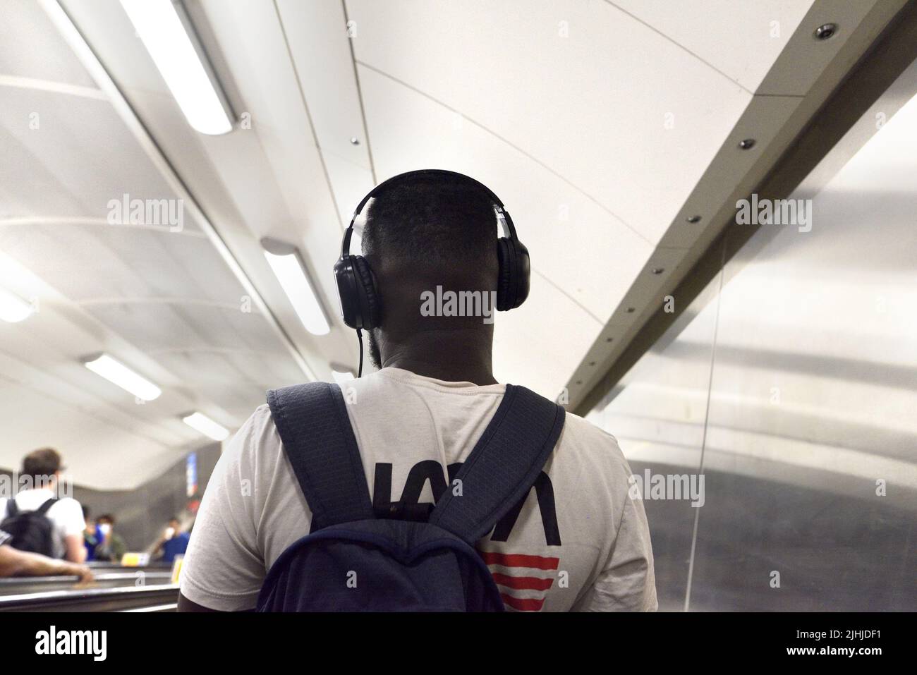 London, England, UK. London Underground - man wearing headphones on a down escalator Stock Photo