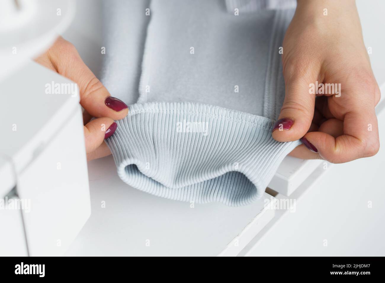 Seamstress look at ready clothes. Garment factory quality control check for defects. Tailors