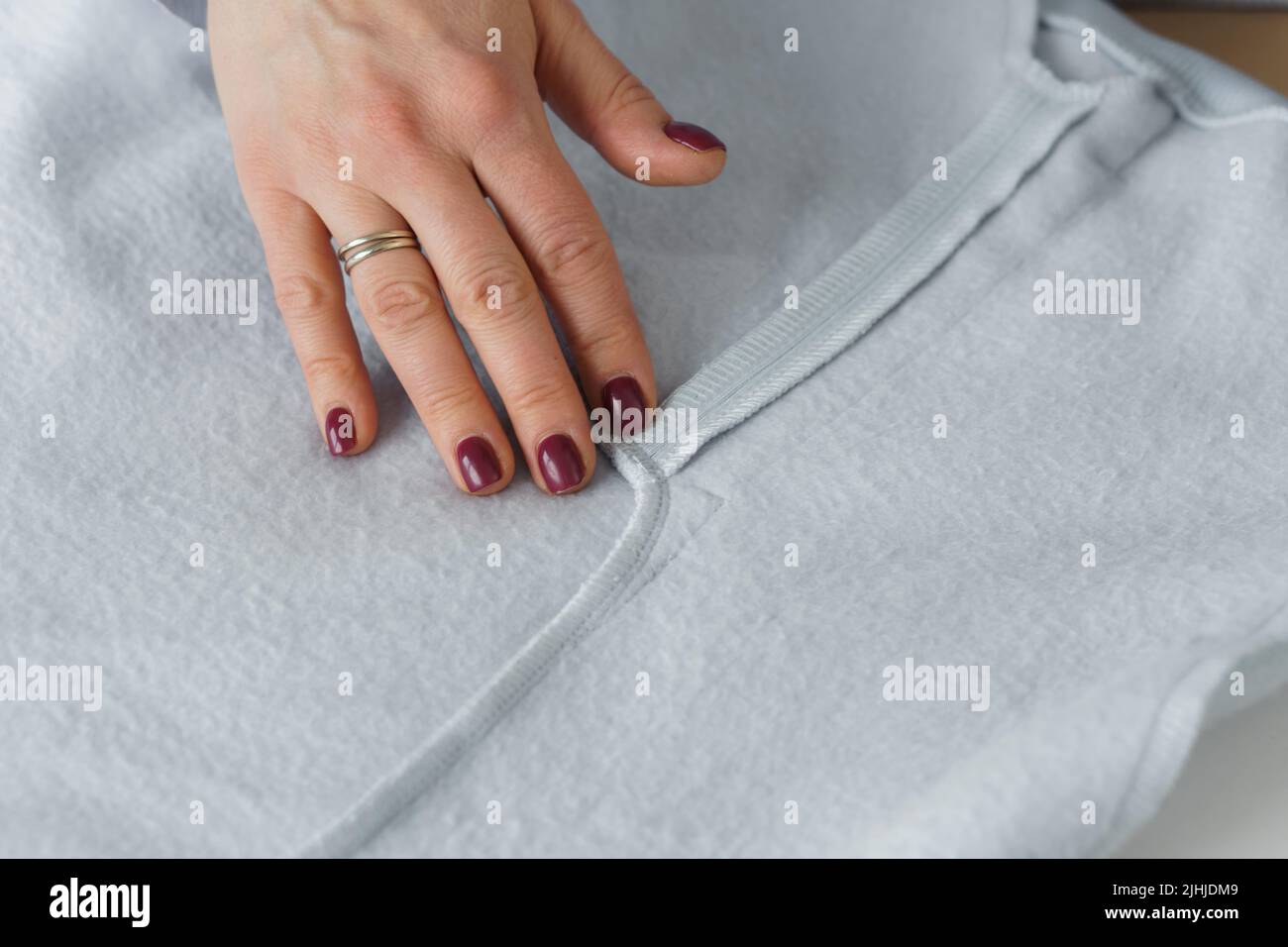 Seamstress look at ready clothes. Garment factory quality control check for defects. Tailors