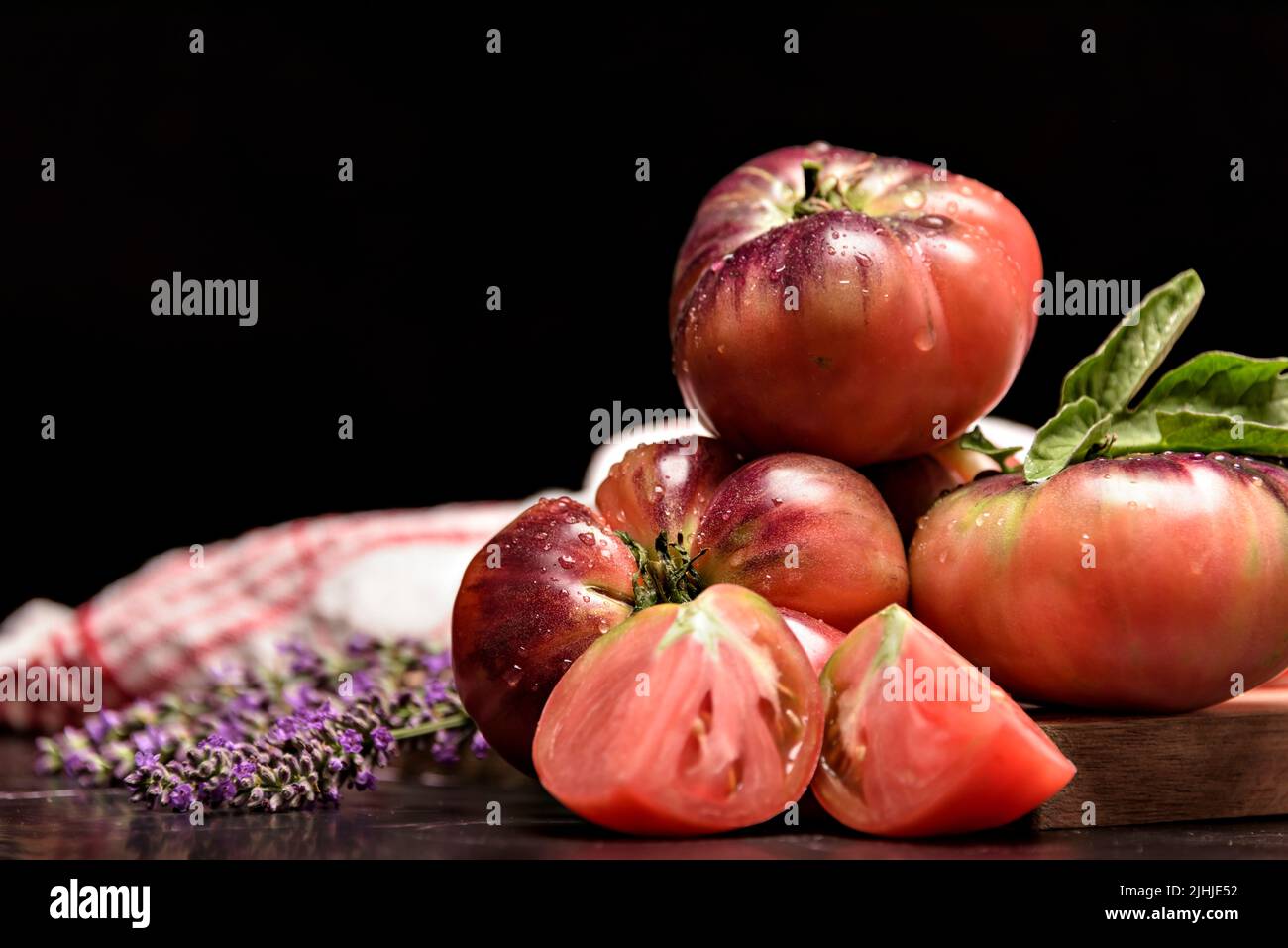 Still life with tiger tomato on wood table Stock Photo - Alamy