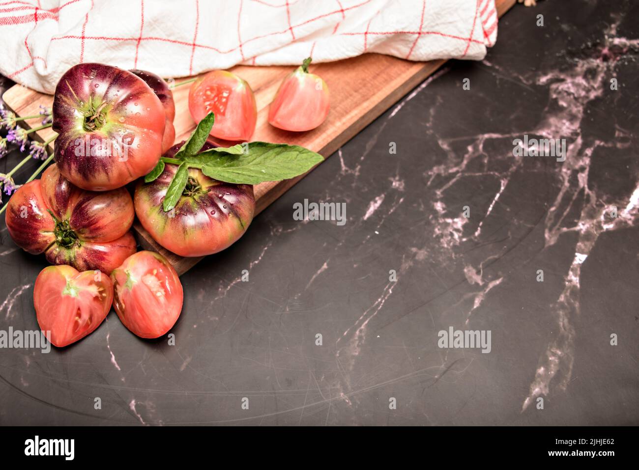 Still life with tiger tomato on wood table Stock Photo - Alamy