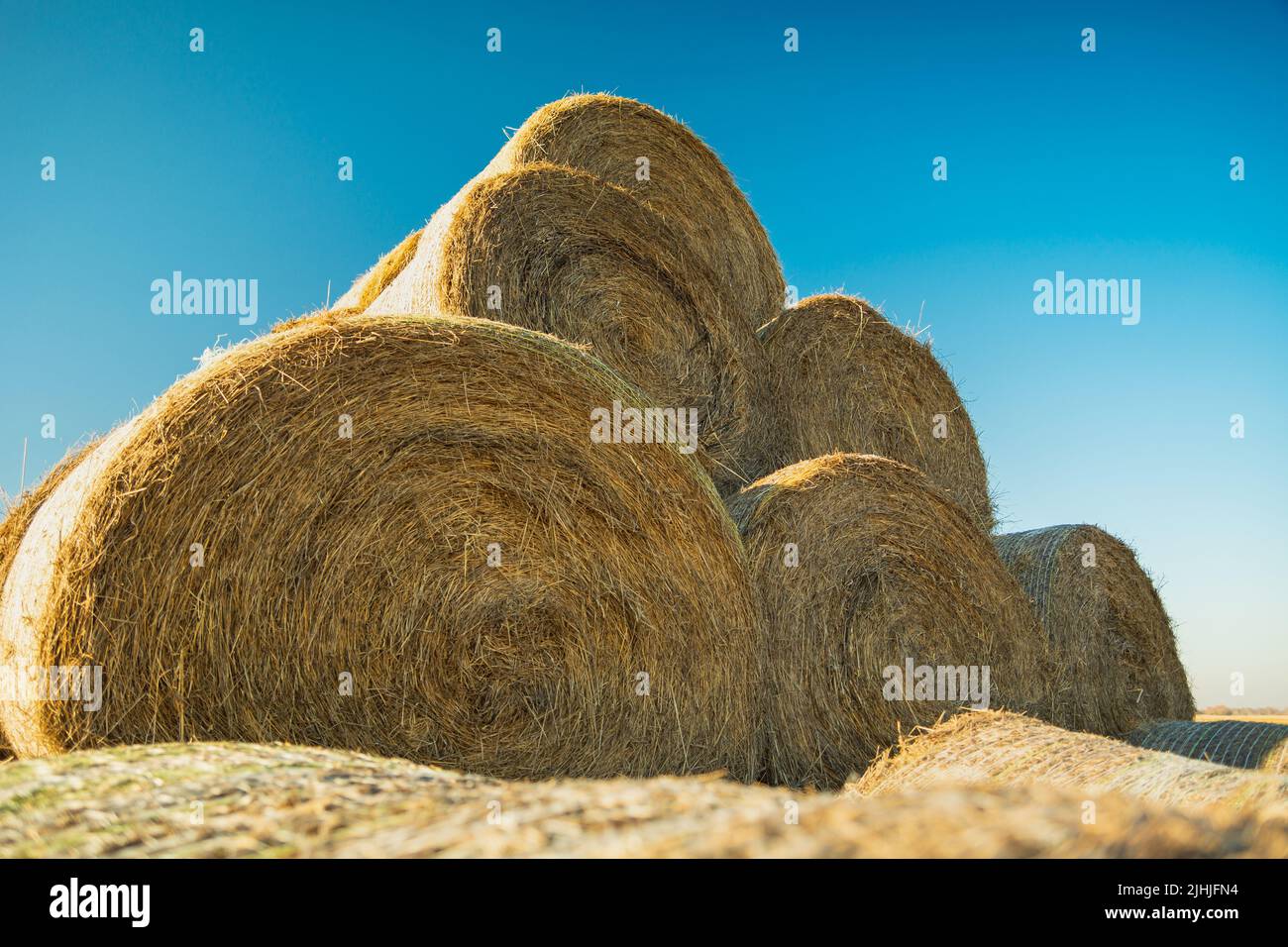 Pyramid of hay bales against the blue sky Stock Photo