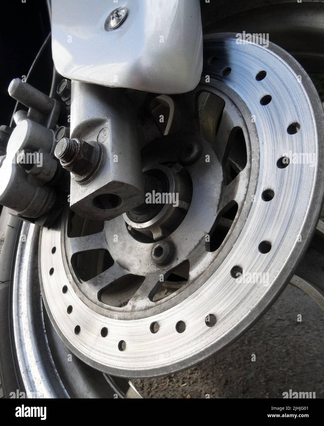 Motorcycle worn disc and caliper of hydraulic brake system Stock Photo