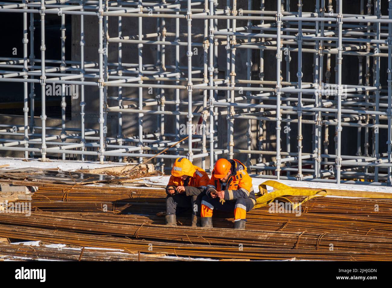 Unrecognizable builders using smartphones during break Stock Photo
