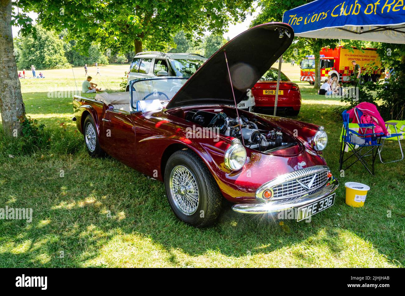 A Daimler SP250 Sports car in burgundy with it's bonnet open revealing the engine bay at The Berkshire Motor Show in Reading, UK Stock Photo
