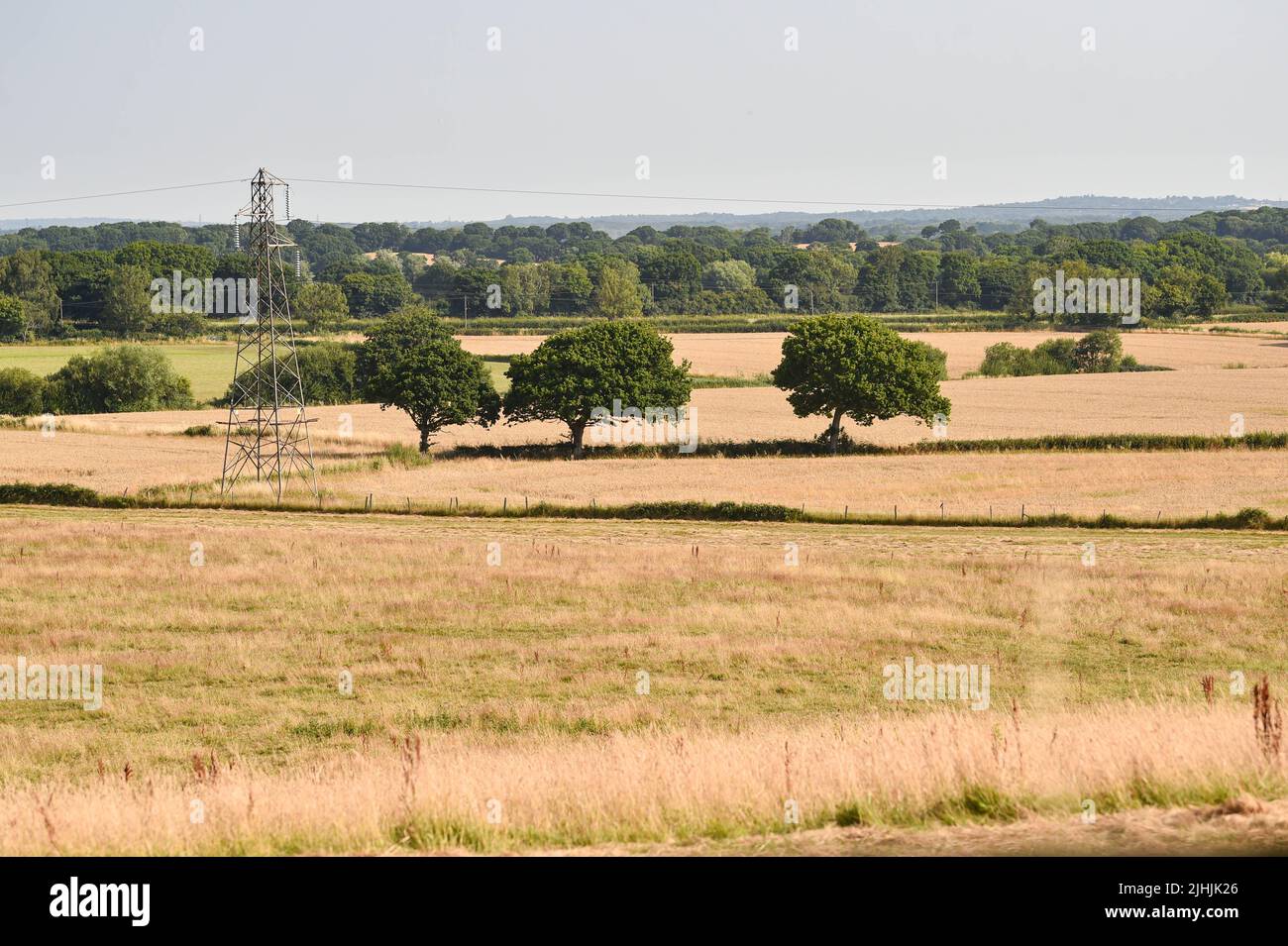 Lewes UK 19th July 2022 - Parched fields by Arlington Reservoir near Lewes in East Sussex during the current heatwave weather as an extreme red weather warning has been issued for today throughout parts of Britain : Credit Simon Dack / Alamy Live News Stock Photo