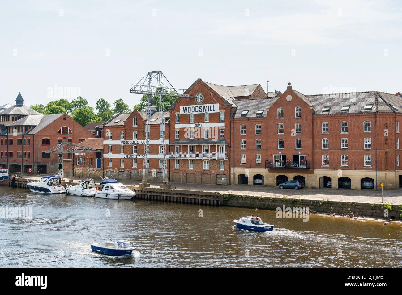 Woodsmill warehouse turned into Queens Hotel fronting river Ouse with pleasure boats York Yorkshire 2022 Stock Photo