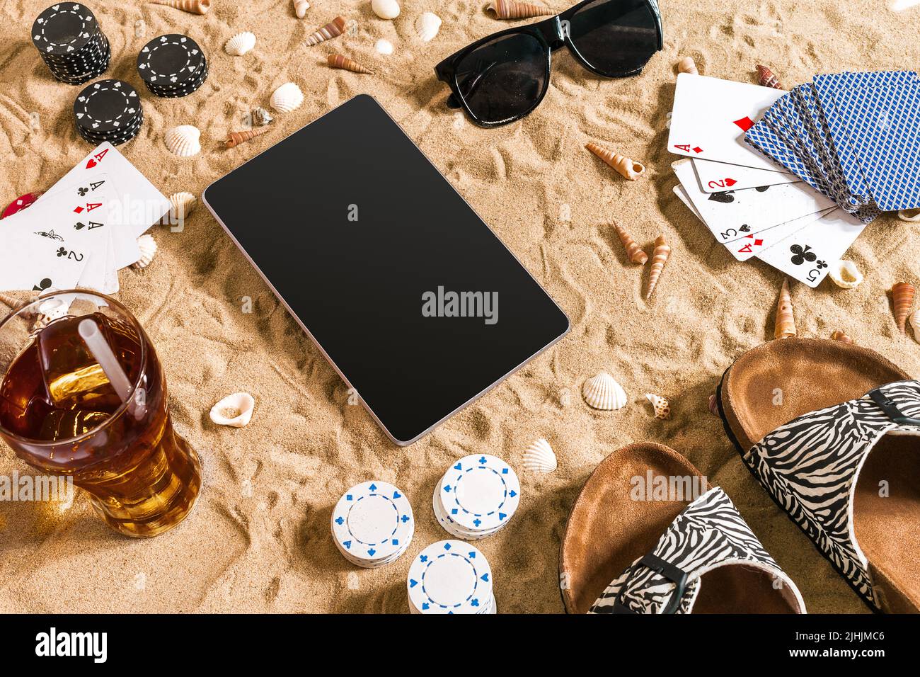 online-poker-game-on-the-beach-with-digital-tablet-and-stacks-of-chips-top-view-2JHJMC6.jpg
