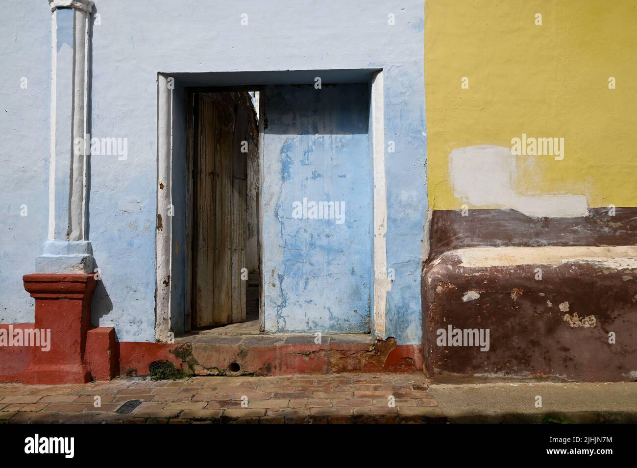 Antique wooden door on a weathered stucco wall in Trinidad, Cuba Stock
