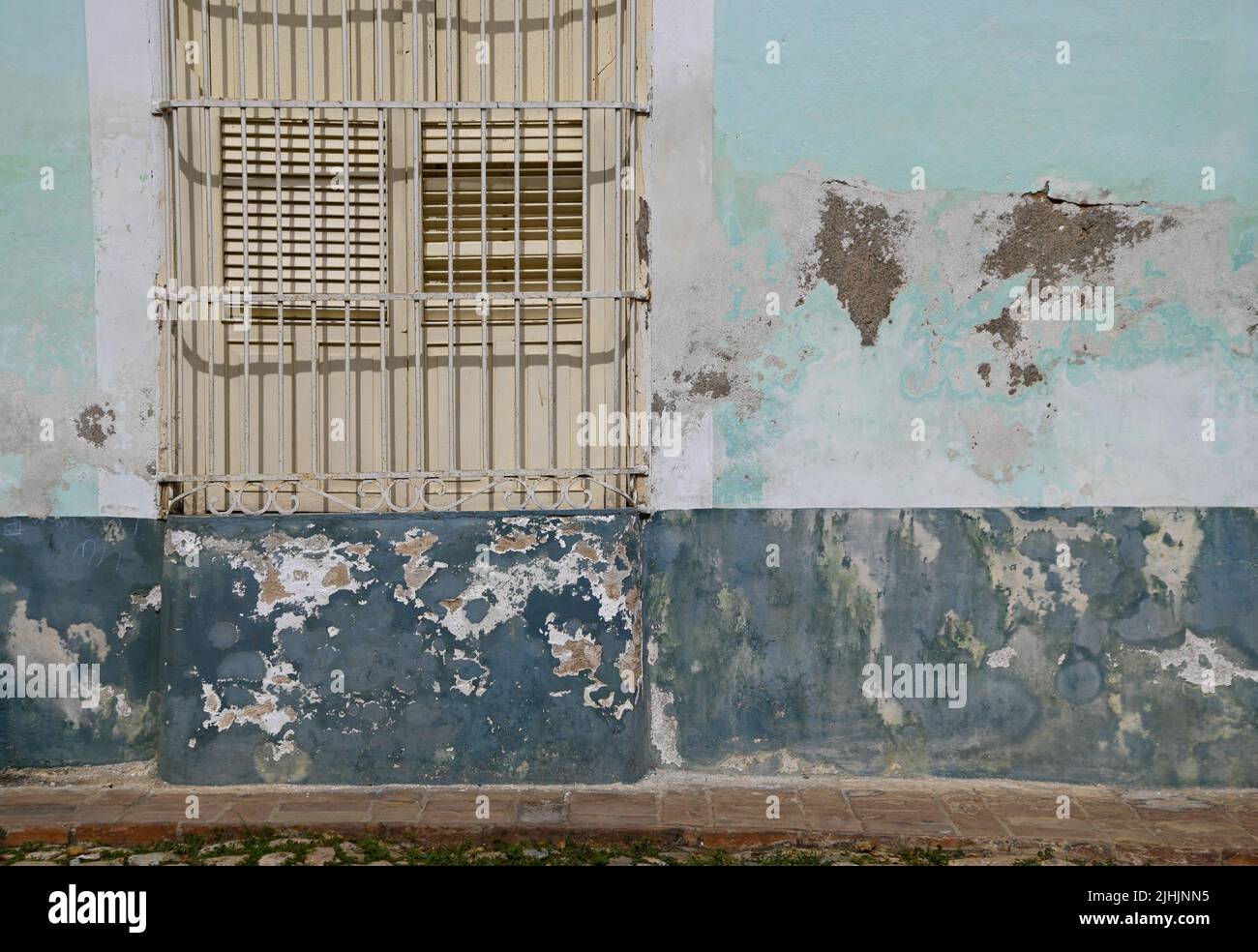 Old Colonial house window with wooden shutters and handcrafted wrought
