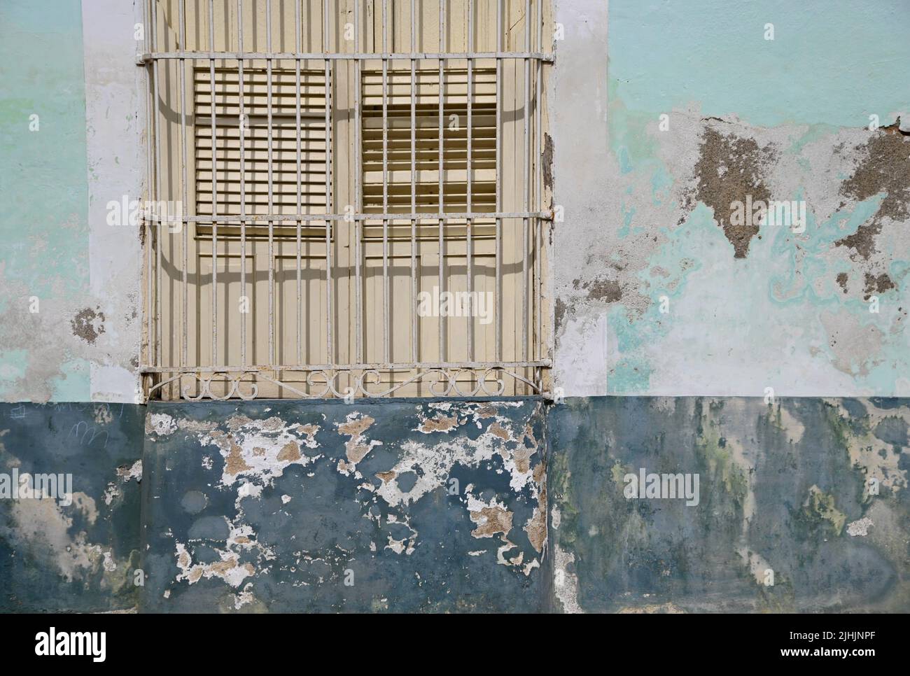 Old Colonial house window with wooden shutters and handcrafted wrought