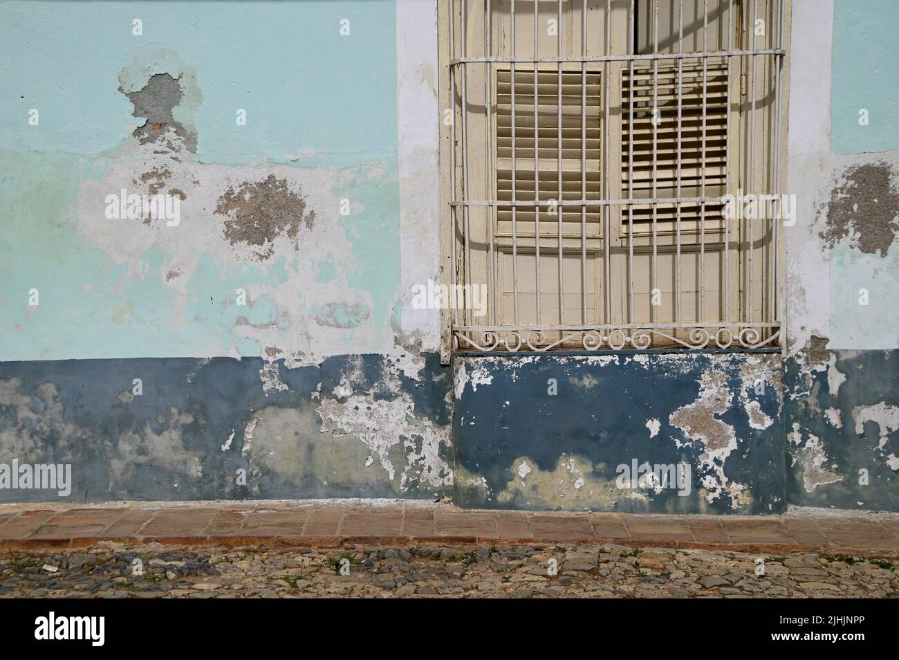 Old Colonial house window with wooden shutters and handcrafted wrought