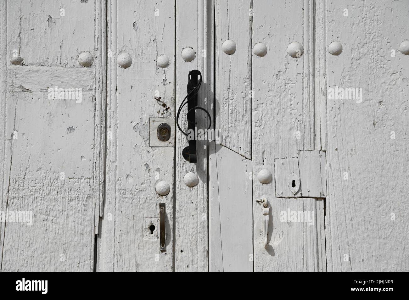 Antique whitewashed wooden door with matching studs and a sol key