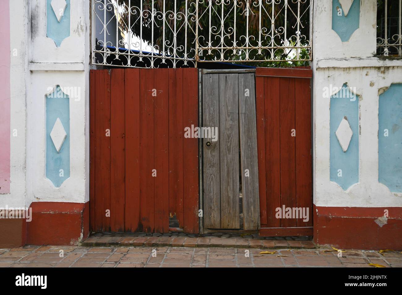 Antique wooden door on a traditional paneled wall in Trinidad, Cuba