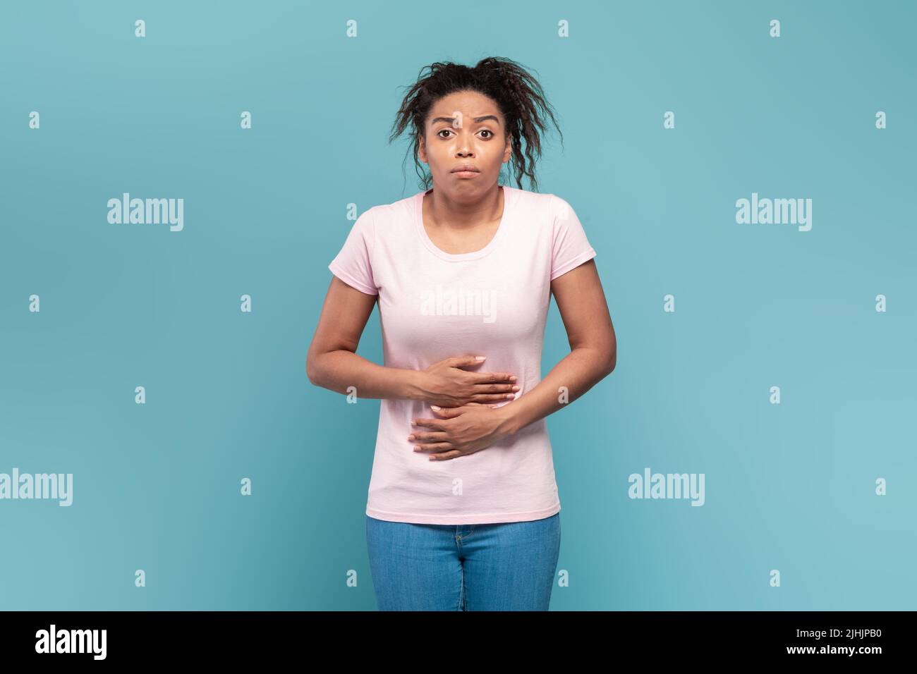 Stomachache, flatulence and nausea concept. Young black lady touching