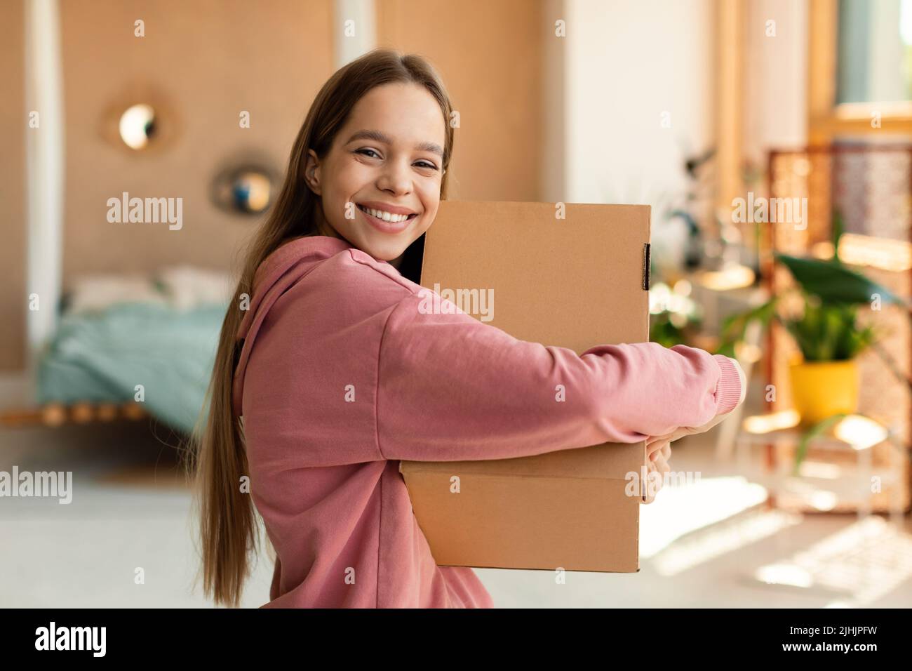 Delivery and shopping. Excited teen customer girl hugging cardboard box