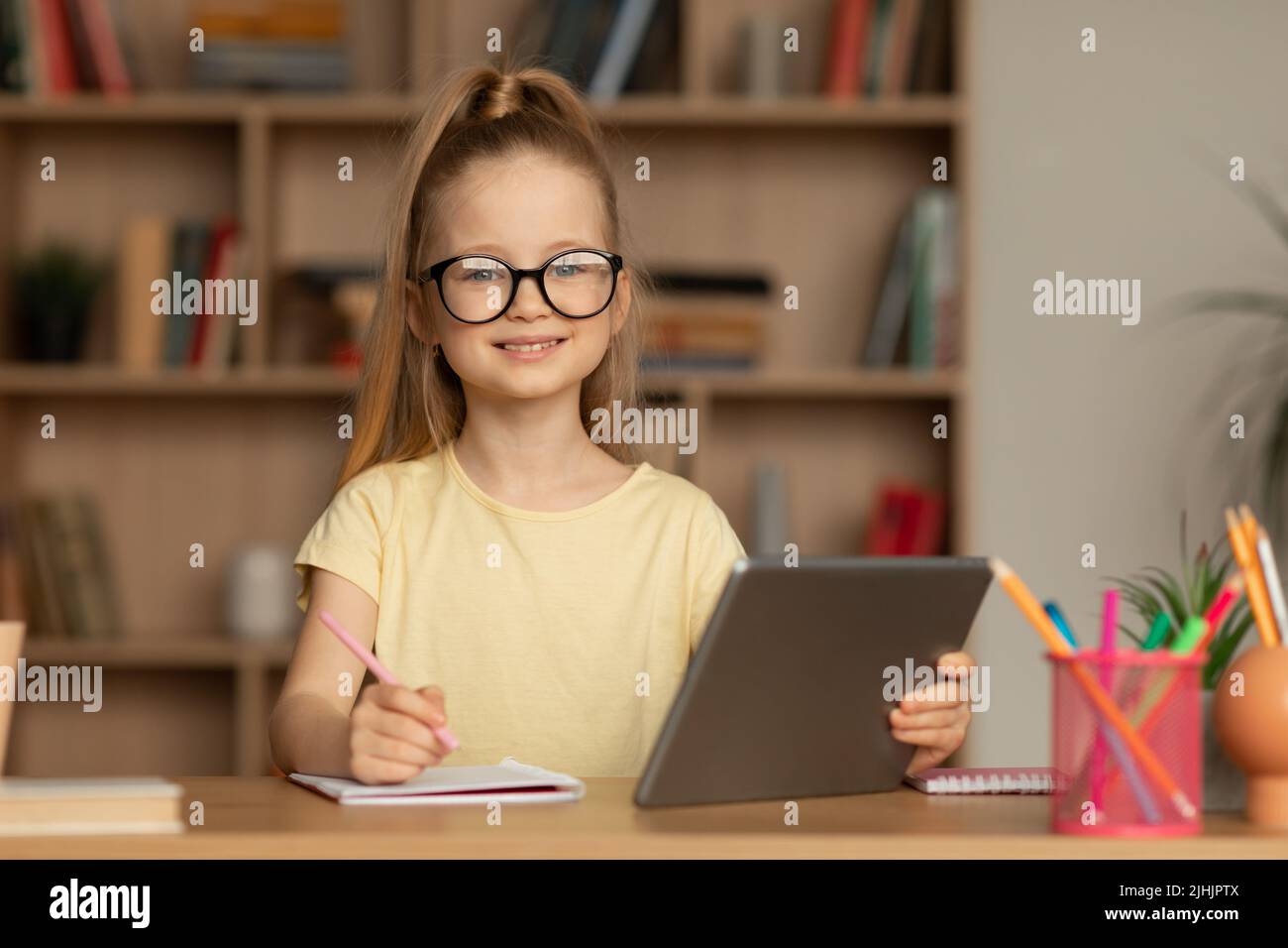 Schoolgirl Taking Notes Using Digital Tablet Posing Sitting Indoors ...