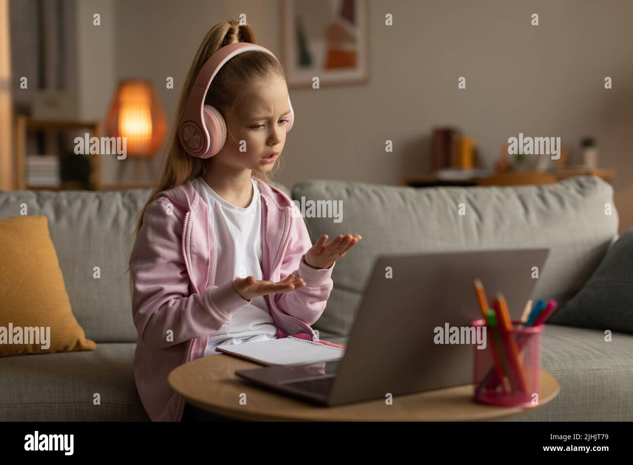 Little Girl Video Calling Learning Online Talking To Laptop Indoors