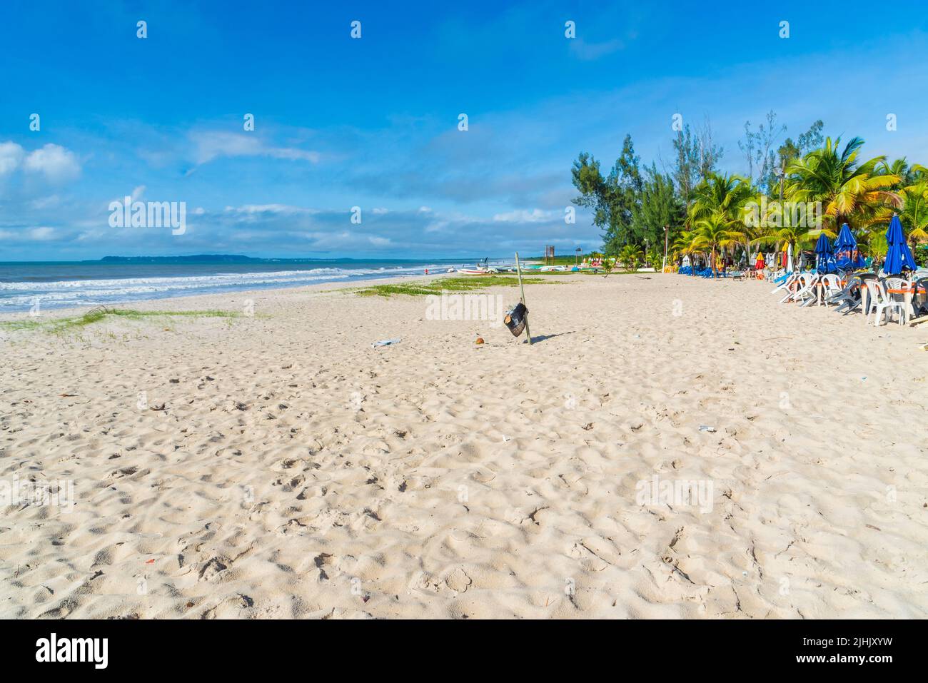 Strong Beach Clear and dense sand against blue sky with clouds and strong sun on ...
