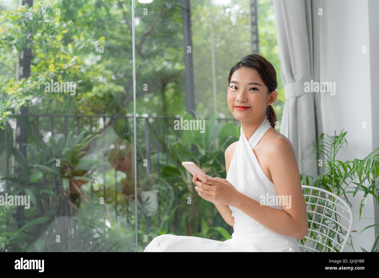 Millennial Korean Woman Shopping Online Or Browsing New App On Mobile Phone Stock Photo