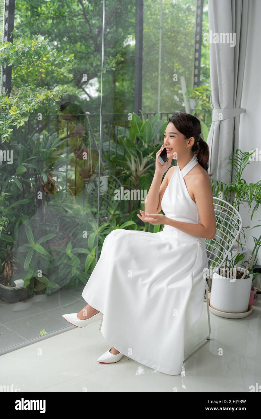 Young woman talking on the mobile in her hotel room. Stock Photo