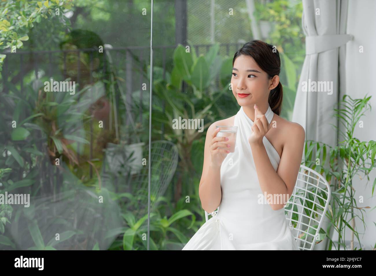 asian young woman holding a glass of water with vitamin has healthy life and she smile at you Stock Photo