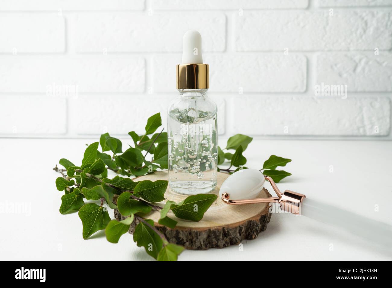 Natural antiaging face serum or essential oil standing on a wooden plate Stock Photo