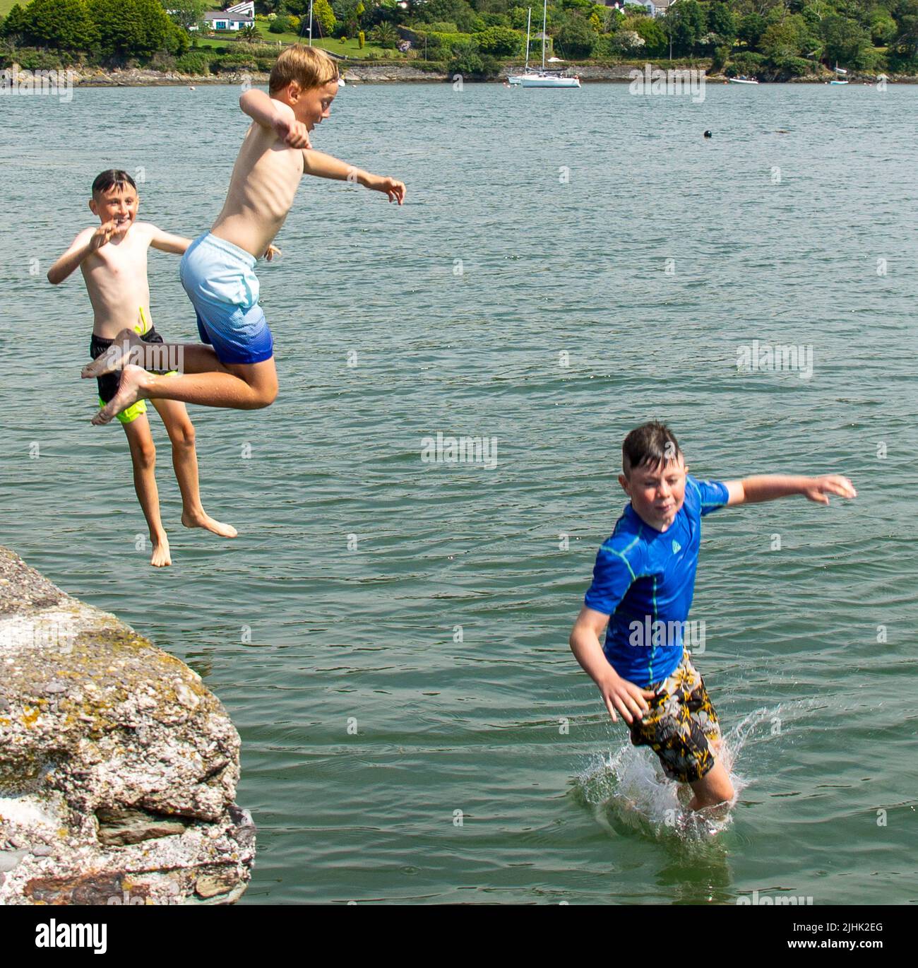 Children on summer holiday or vacation jumping into the sea. Stock Photo