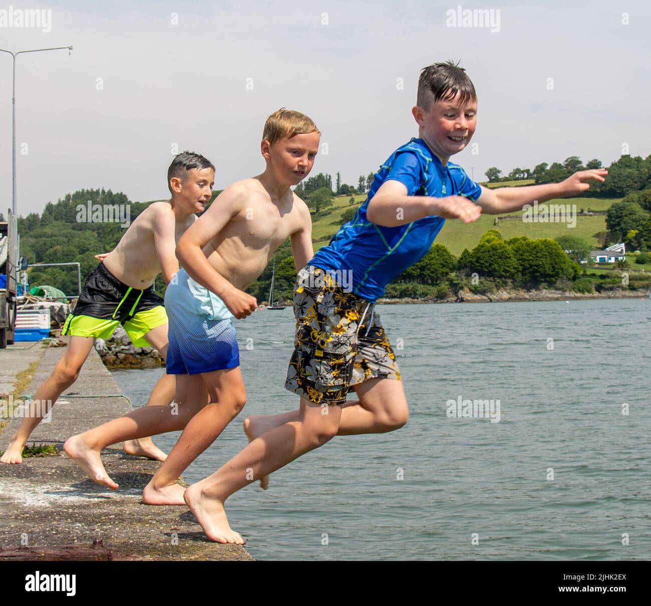 Children on summer holiday or vacation jumping into the sea. Stock Photo