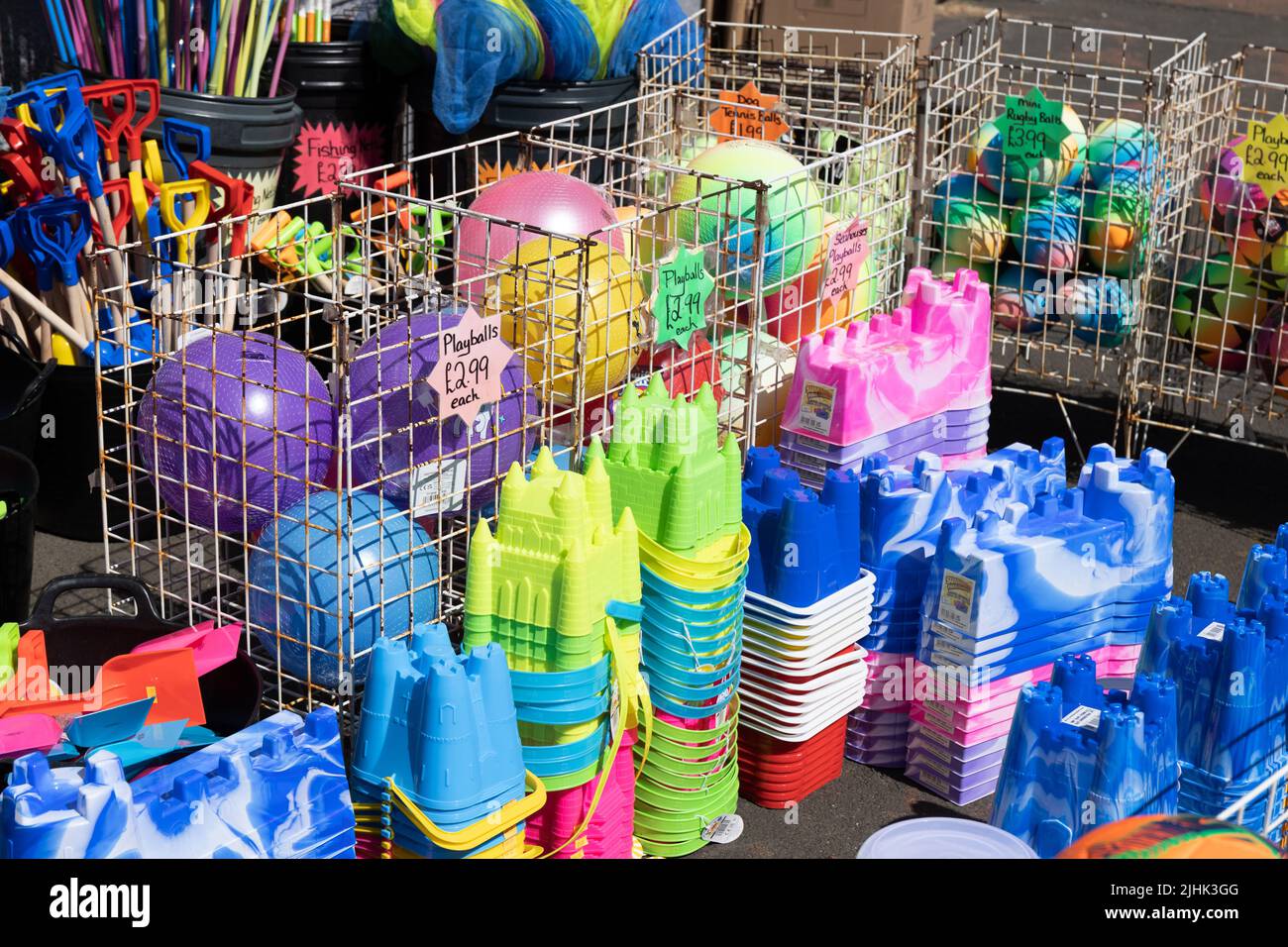 Colourful childrens beach balls, buckets and spades and fishing nets at