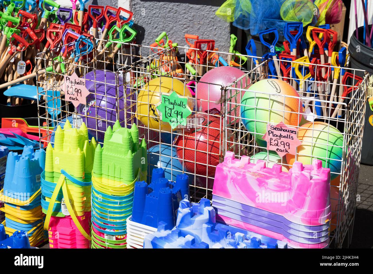 Colourful childrens beach balls, buckets and spades and fishing nets at
