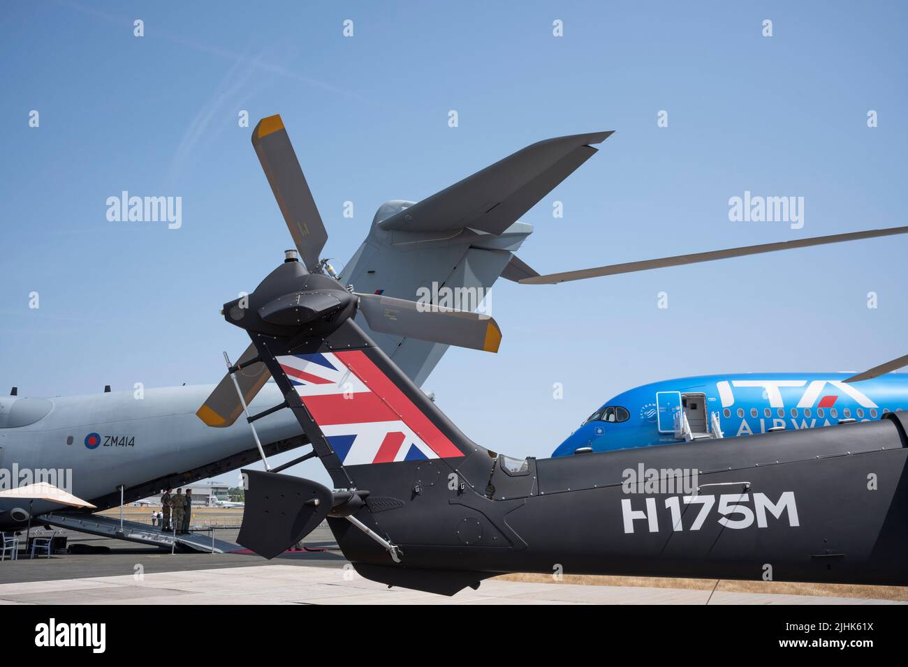 Assorted Airbus aircraft in the foreground including an RAF A400, the tail of a H175M helicopter and the nose of an A350-900 at the Farnborough Airshow, on 18th July 2022, at Farnborough, England. The Farnborough International Airshow (FIA) is an aerospace and defence industry trade fair which, due to Covid, is being held for the first time in four years. The pandemic has had a major impact on commercial aviation, while the war in Ukraine has changed the mindset for defence industries. There are 1,200 exhibitors from 42 countries here with organisers hoping to attract more than 80,000 visitors Stock Photo