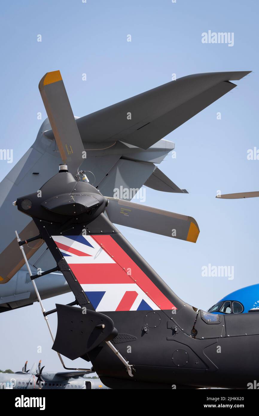Assorted Airbus aircraft in the foreground including an RAF A400, the tail of a H175M helicopter and the nose of an A350-900 at the Farnborough Airshow, on 18th July 2022, at Farnborough, England. The Farnborough International Airshow (FIA) is an aerospace and defence industry trade fair which, due to Covid, is being held for the first time in four years. The pandemic has had a major impact on commercial aviation, while the war in Ukraine has changed the mindset for defence industries. There are 1,200 exhibitors from 42 countries here with organisers hoping to attract more than 80,000 visitors Stock Photo