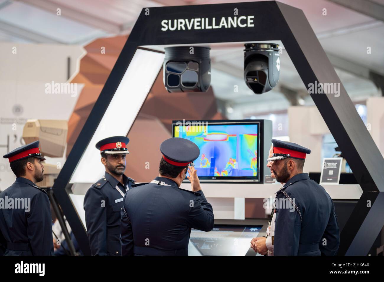 Foreign military officers discuss technology in front of Thermal Imaging surveillance cameras and screen by 'Teledyne FLIR' at the Farnborough Airshow, on 18th July 2022, at Farnborough, England. Teledyne FLIR specializes in thermal imaging cameras and sensors. Its main customers are governments, The Farnborough International Airshow (FIA) is an aerospace and defence industry trade fair which, due to Covid, is being held for the first time in four years. The pandemic has had a major impact on commercial aviation, while the war in Ukraine has changed the mindset for defence industries. There ar Stock Photo