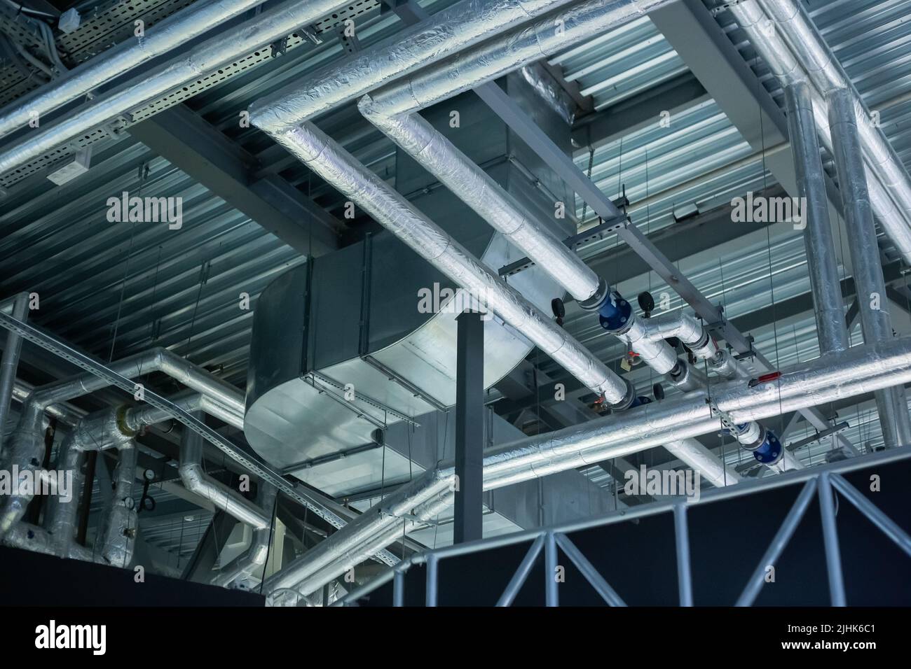Air conditioning, ventilation ducts and heating pipes of buildings. Laying of engineering networks under ceiling. Industrial background Stock Photo