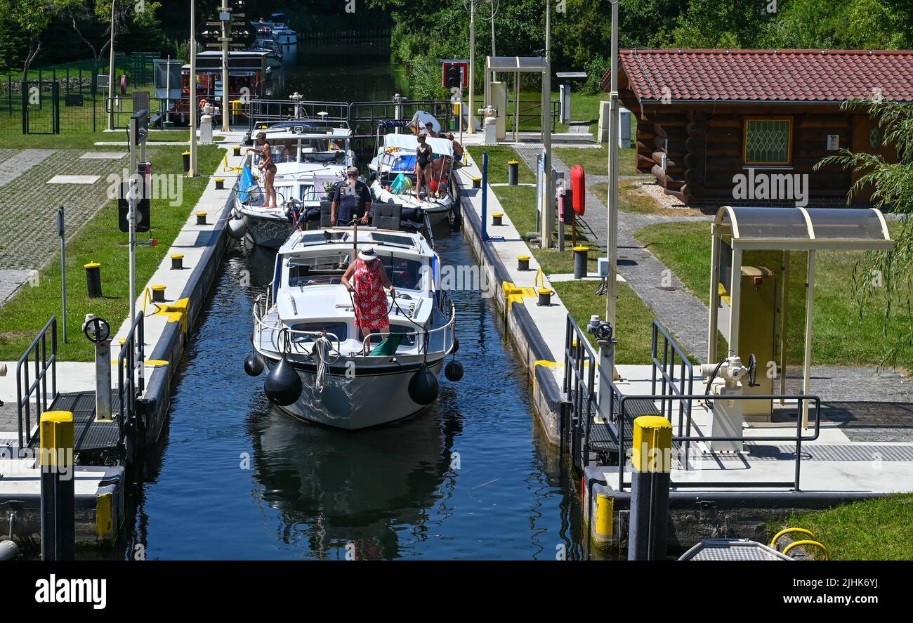 Wendisch Rietz, Germany. 19th July, 2022. Boats leave the Wendisch Rietz lock. The lock connects Lake Storkow with Lake Scharmützel. Credit: Patrick Pleul/dpa/Alamy Live News Stock Photo