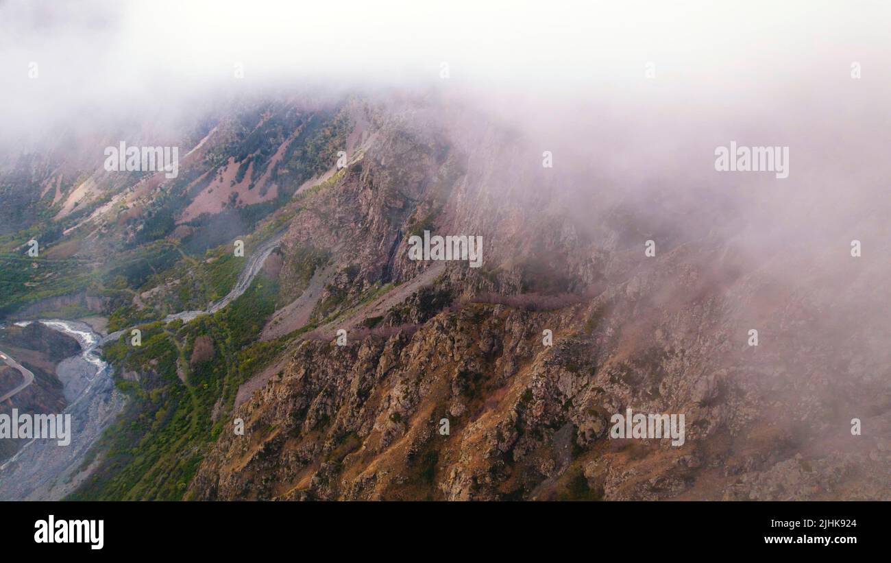 Misty fog covering the drone filming aerial view of beautiful mountains. High quality photo Stock Photo
