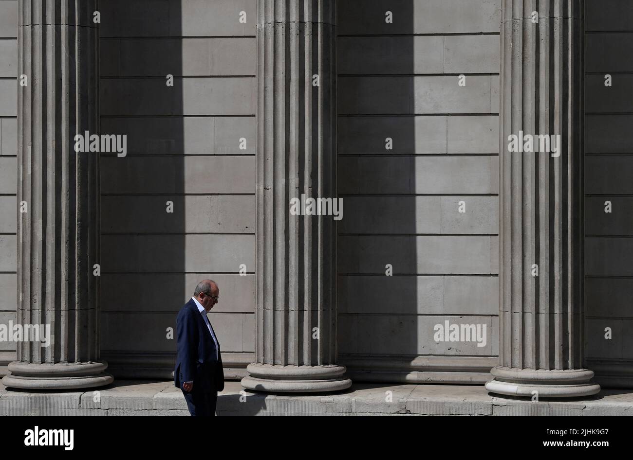 A worker walks past the Bank of England during the hot weather in the City of London financial district, London, Britain, July 19, 2022. REUTERS/Toby Melville Stock Photo
