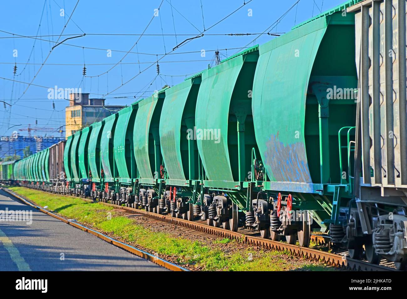 Green cargo bunker wagon line on the station in sunny day, long  railway train transportation diversity Stock Photo
