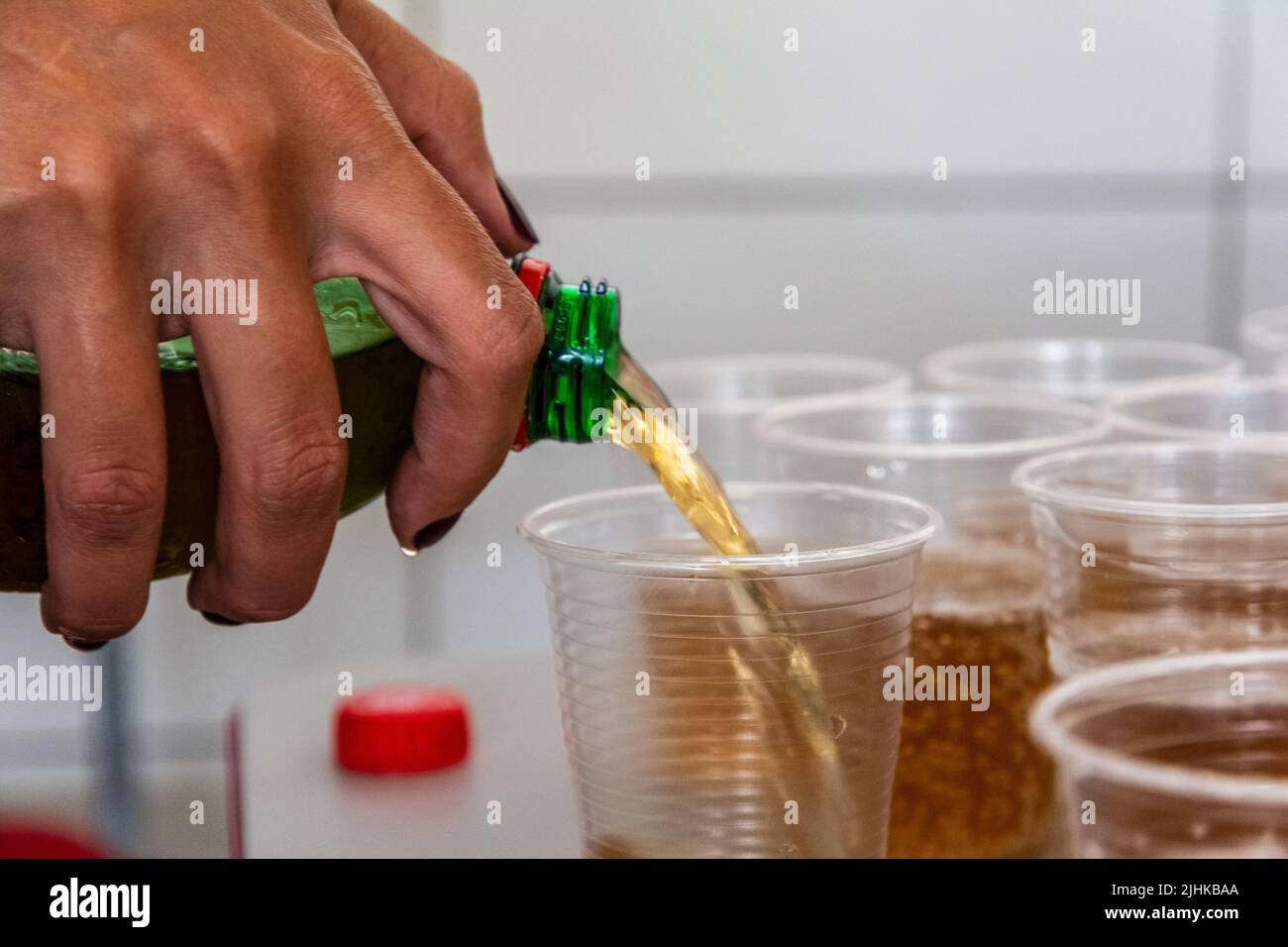 Soda being poured into a plastic cup to be drunk. Salvador, Bahia ...