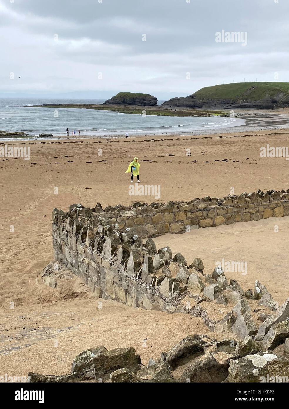 People wearing raincoats at Bundoran Beach, Co Donegal, as thunderstorms hit parts of Donegal. Two weather warnings have been issued for Ireland with high temperatures and thunderstorms to hit Munster and Leinster. Stock Photo