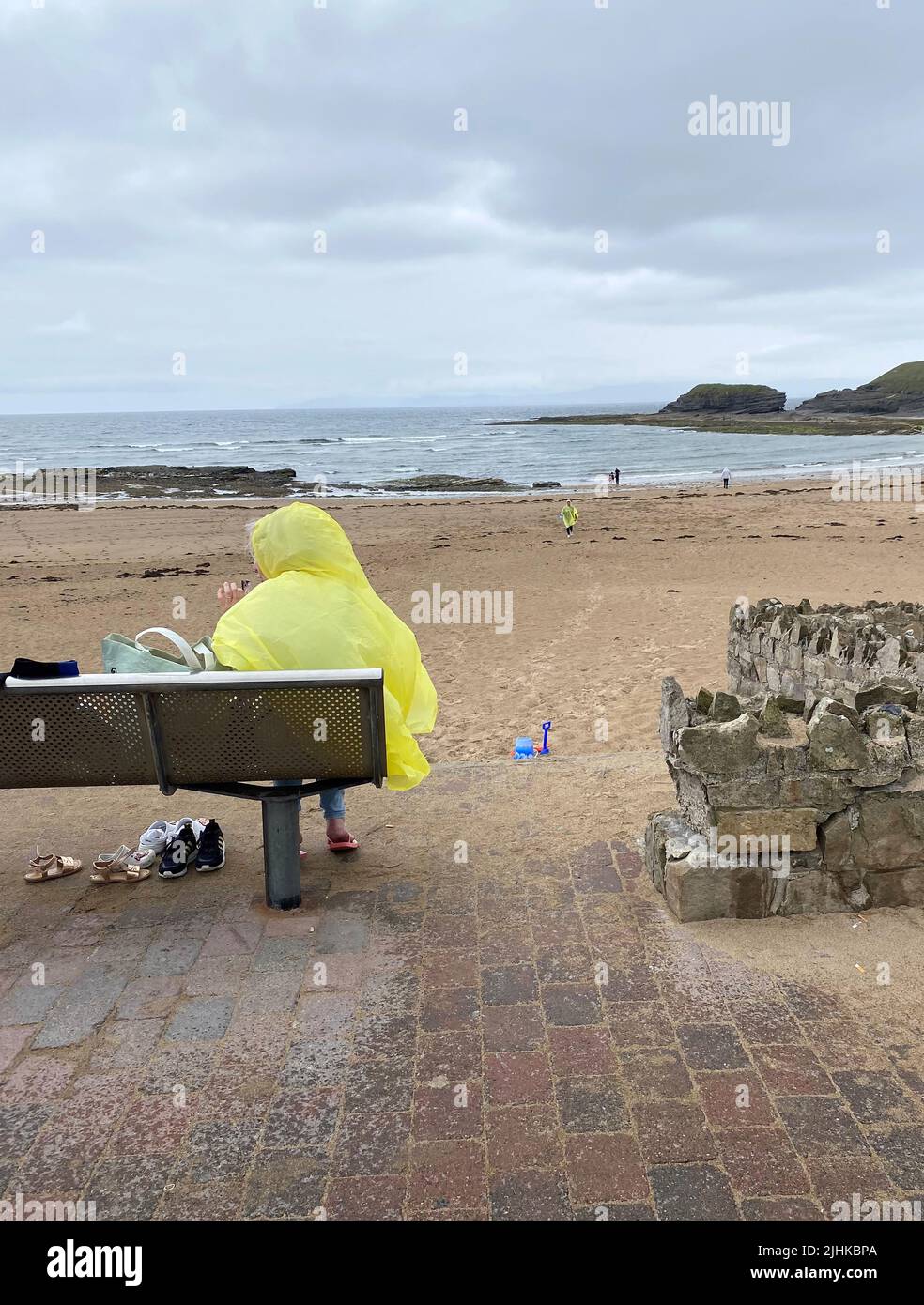 People wearing raincoats at Bundoran Beach, Co Donegal,Â as thunderstorms hit parts of Donegal.Â Two weather warnings have been issued for Ireland with high temperatures and thunderstorms to hit Munster and Leinster. Stock Photo