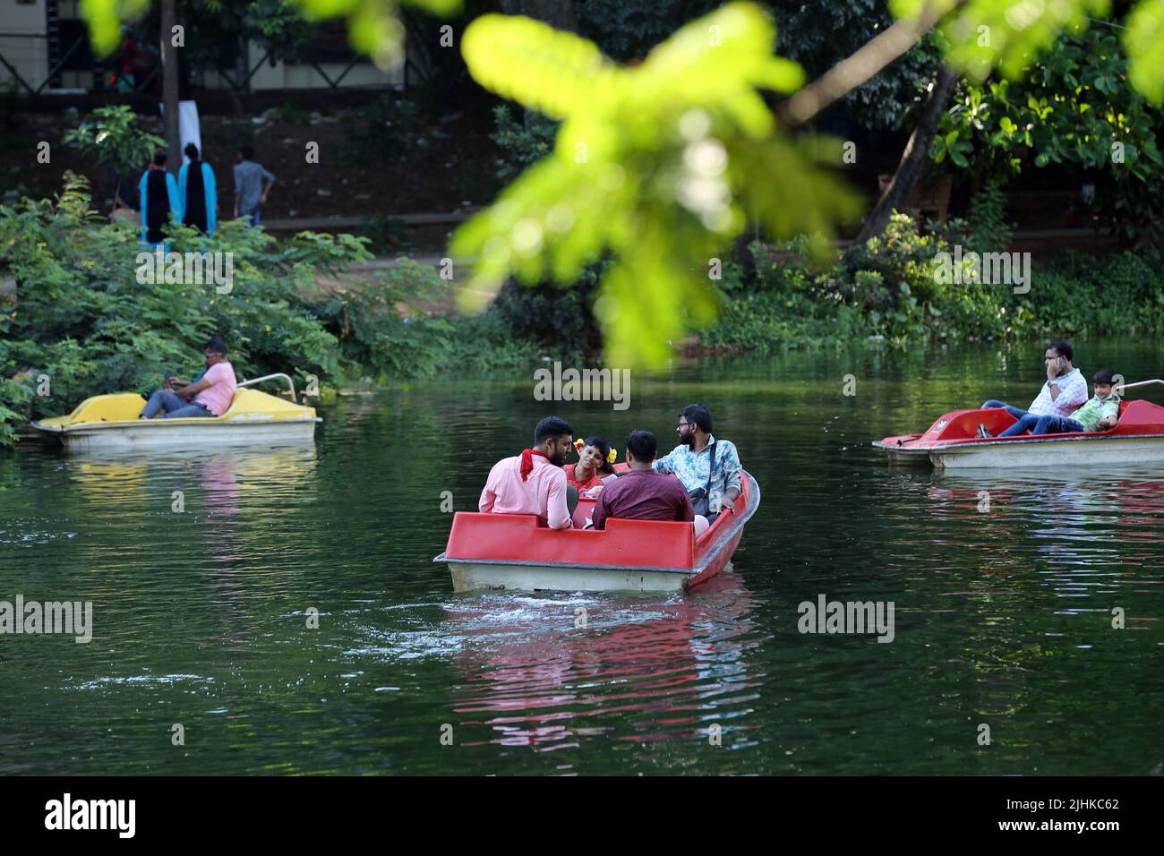 People along with their family and friends enjoying boat riding on Dhanmondi lake to celebrate eid festival, Dhaka, Bangladesh Stock Photo