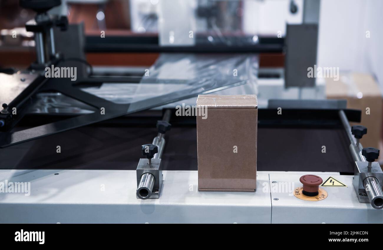 Shrink film package wrapping machine. Wrapping packaging of box