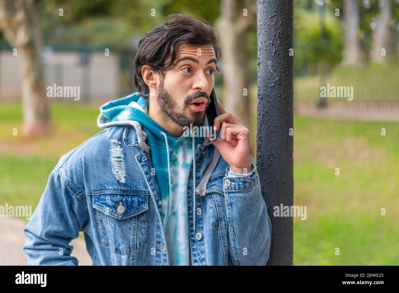 Young latin man talking on cell phone in a park Stock Photo
