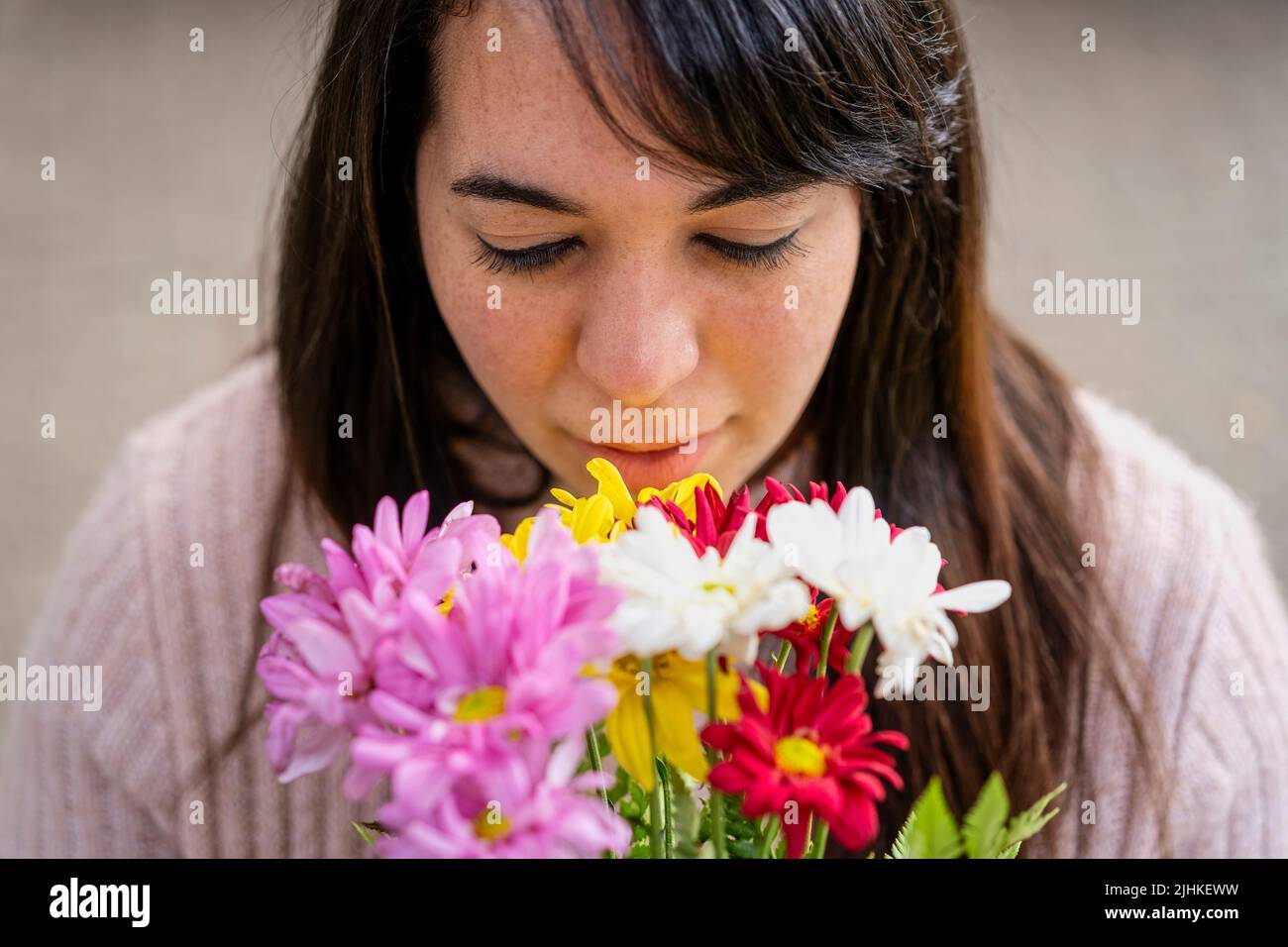 Close-up portrait of a young Latin woman holding a bouquet of flowers Stock Photo